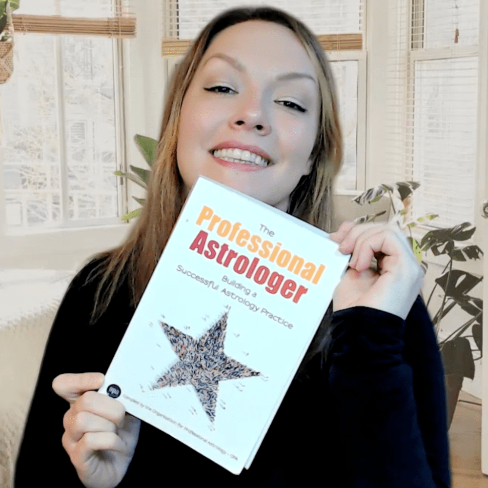 Stefanie James holding a copy of The Professional Astrologer by the OPA